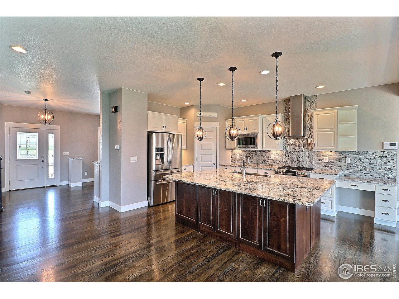 9004 19th Street Greeley, CO 80634 - Photo 12 of 49 a kitchen with stainless steel appliances kitchen island a hardwood floor and a view of living room