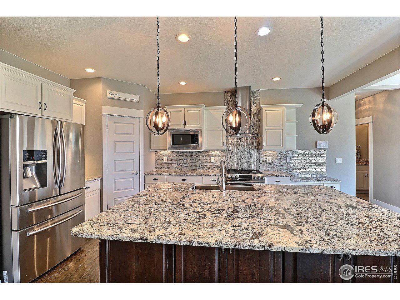 9004 19th Street Greeley, CO 80634 - Photo 13 of 49 a large kitchen with a table and stainless steel appliances