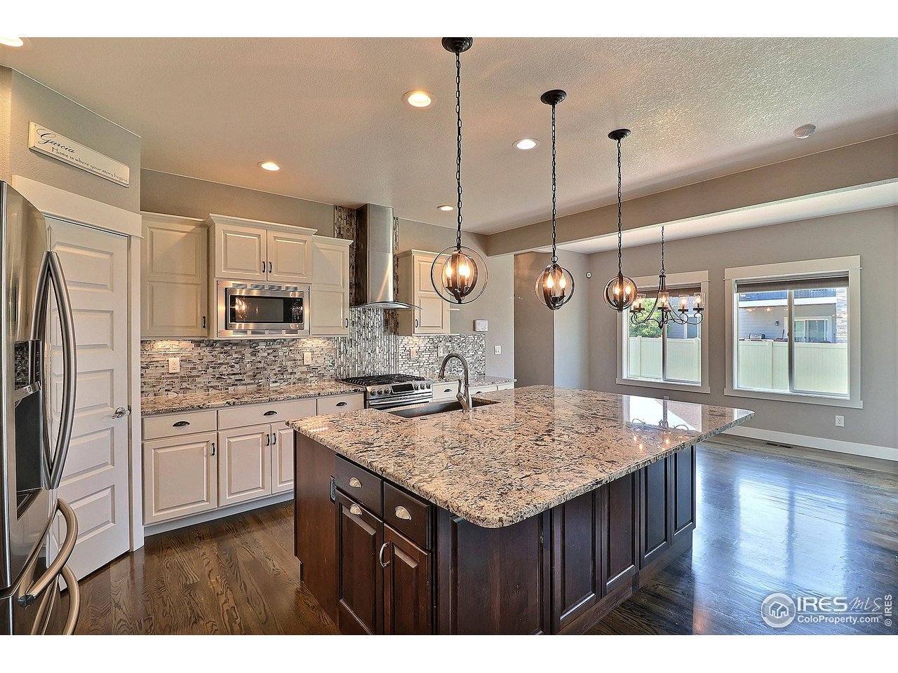 9004 19th Street Greeley, CO 80634 - Photo 14 of 49 a kitchen with stainless steel appliances kitchen island granite countertop a stove refrigerator and wooden floor