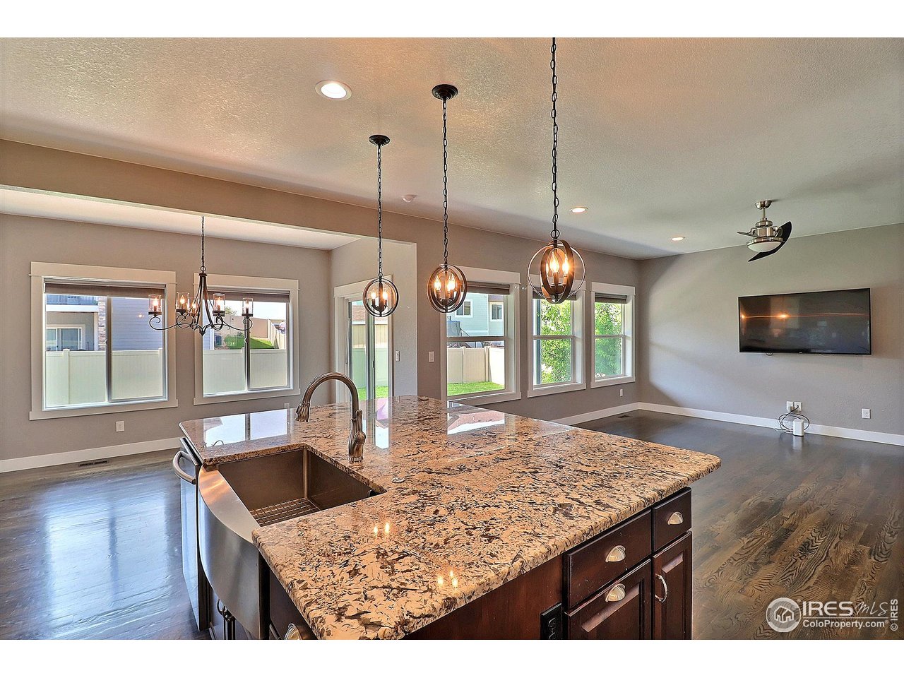 9004 19th Street Greeley, CO 80634 - Photo 15 of 49 a kitchen with kitchen island granite countertop sink and wooden floor