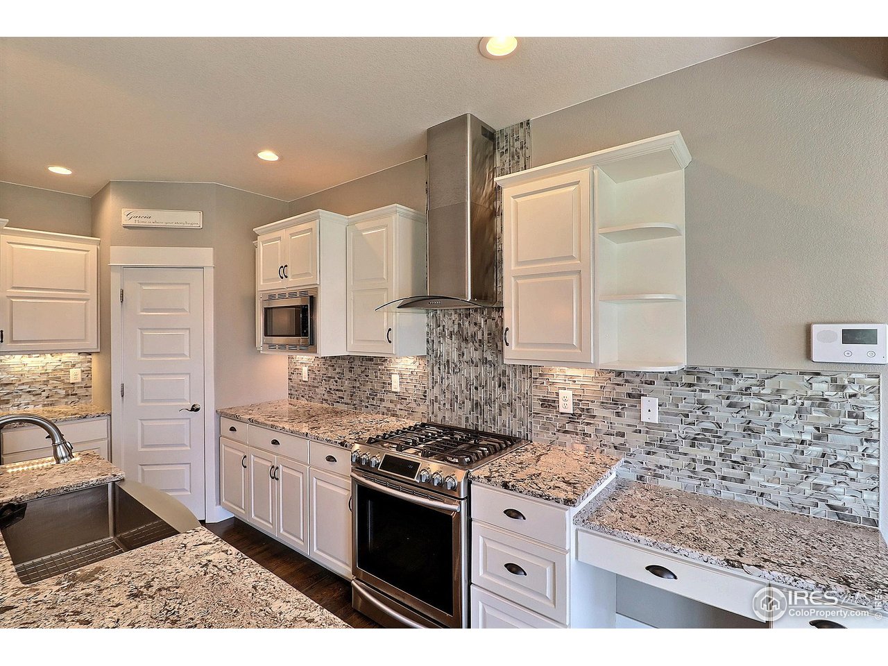 9004 19th Street Greeley, CO 80634 - Photo 18 of 49 a kitchen with stainless steel appliances granite countertop a stove a sink and a microwave