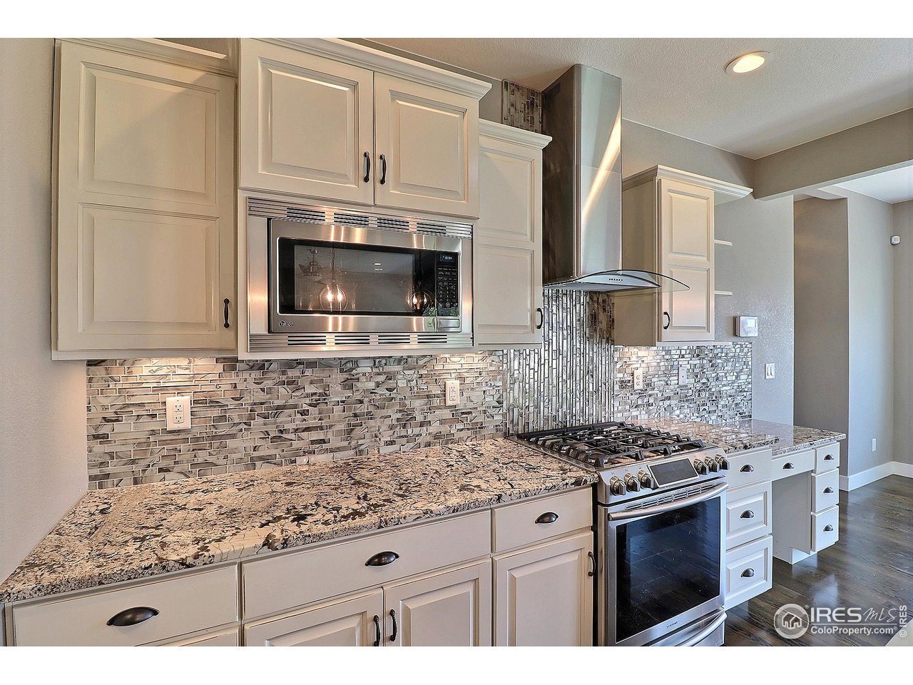 9004 19th Street Greeley, CO 80634 - Photo 19 of 49 a kitchen with stainless steel appliances granite countertop a stove microwave and cabinets