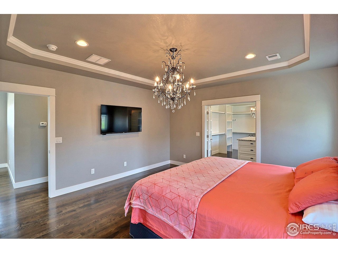 9004 19th Street Greeley, CO 80634 - Photo 27 of 49 a bedroom with a large bed and a chandelier