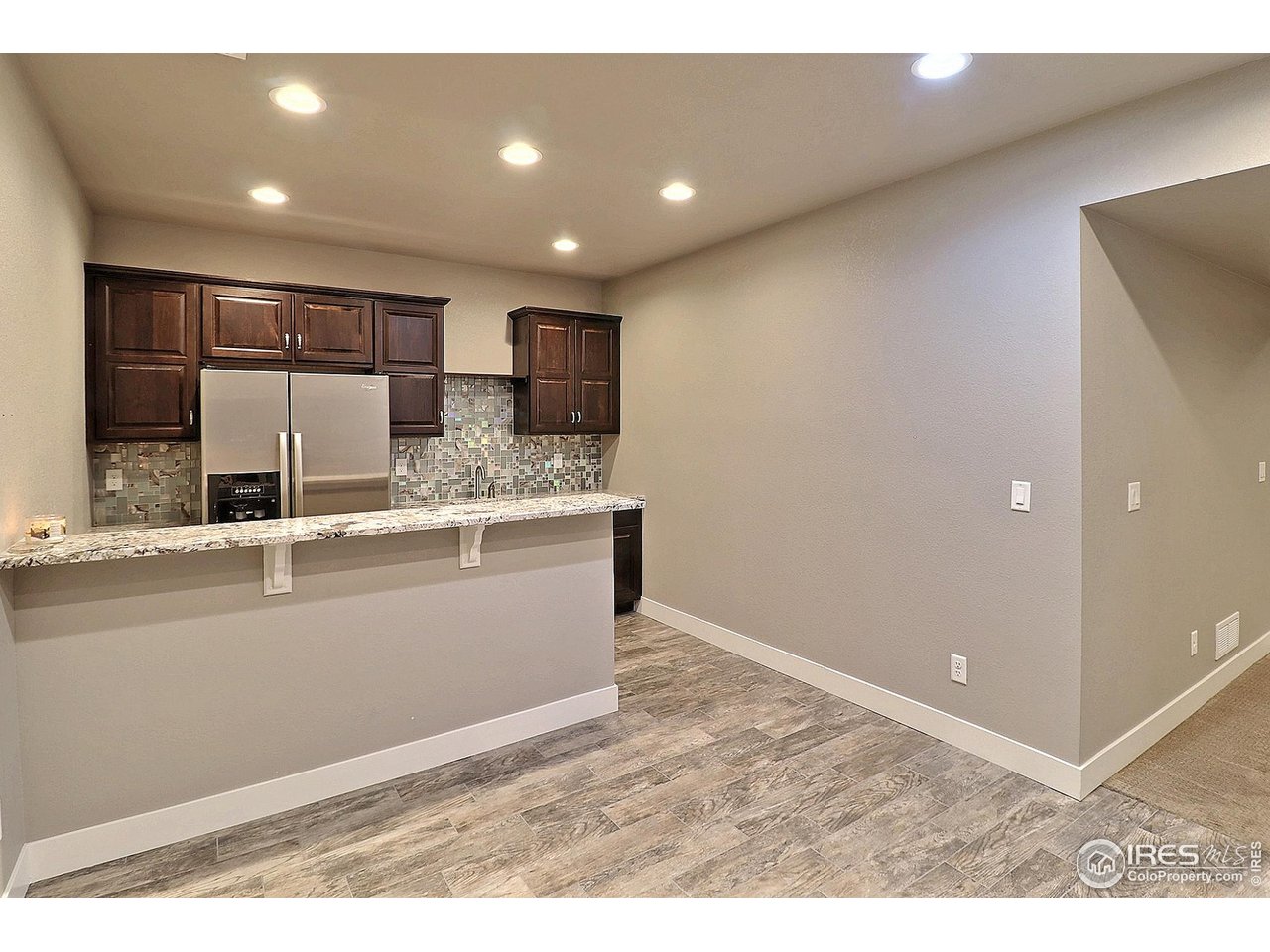 9004 19th Street Greeley, CO 80634 - Photo 37 of 49 a living room with stainless steel appliances kitchen island granite countertop a sink and cabinets
