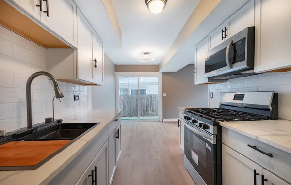 a kitchen with stainless steel appliances granite countertop a sink a stove and a microwave