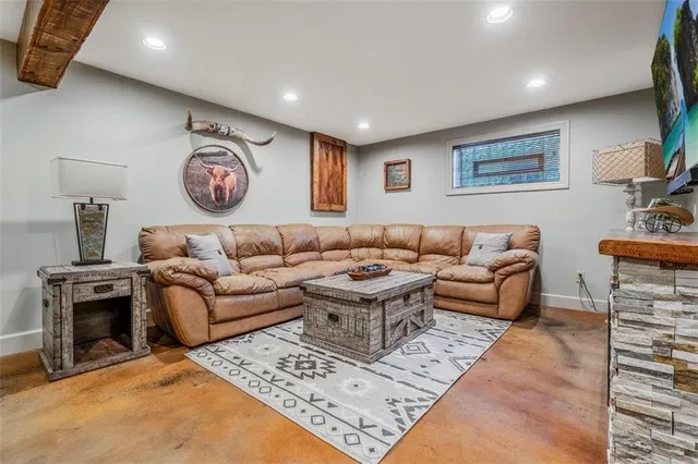 a living room with furniture a flat screen tv and a fireplace