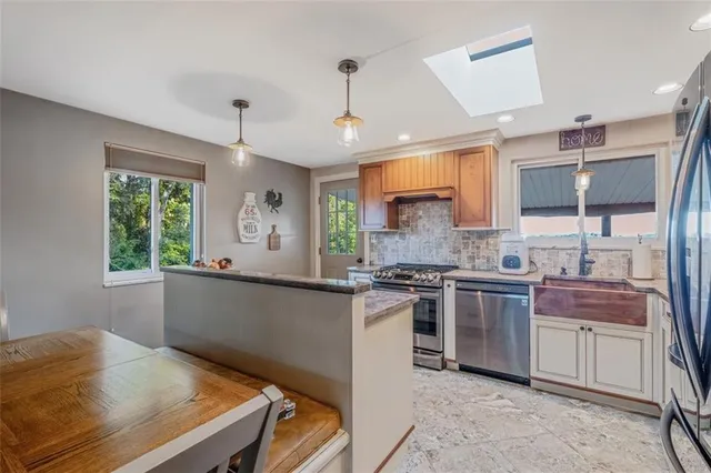 a kitchen with stainless steel appliances granite countertop a sink stove and refrigerator