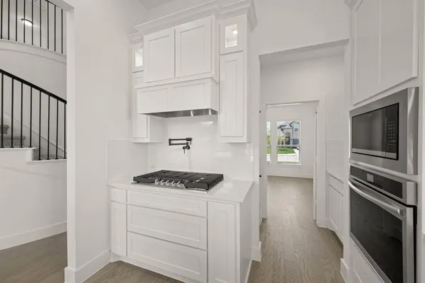 a kitchen with white cabinets and white appliances