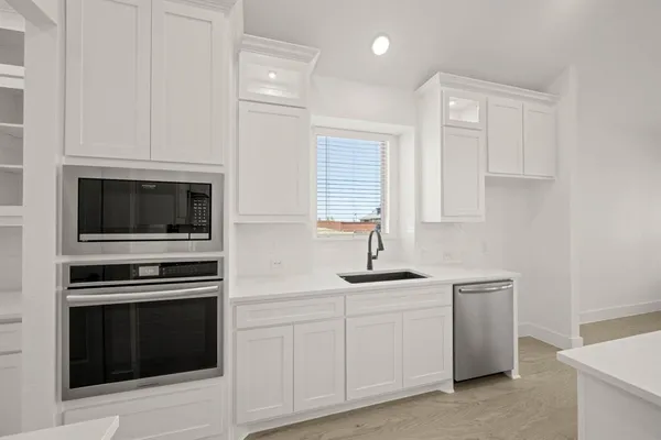 a kitchen with white cabinets and stainless steel appliances