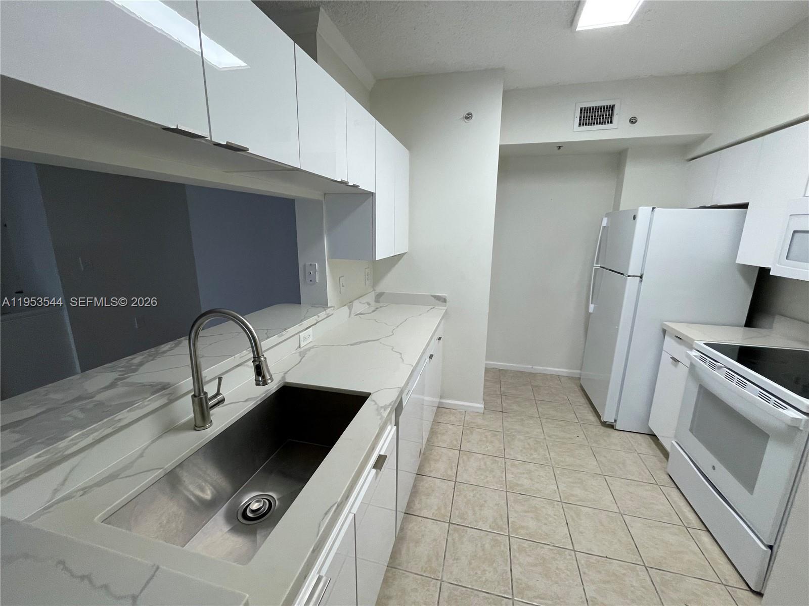 17125 North Bay Road, Unit 3404 Sunny Isles Beach, FL 33160 - Photo 9 of 20 a kitchen with stainless steel appliances a stove a sink and a refrigerator