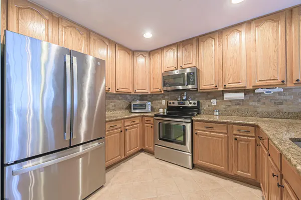 a kitchen with stainless steel appliances granite countertop a refrigerator sink and cabinets