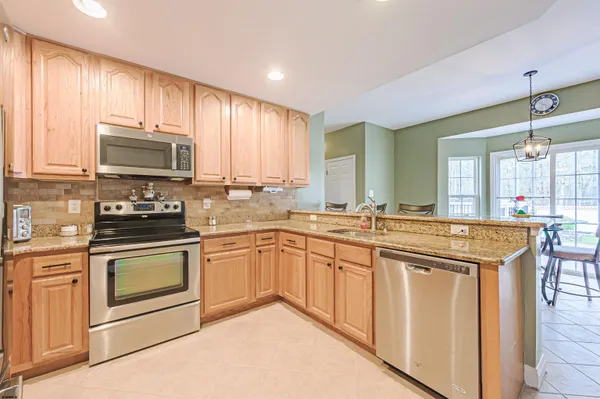a kitchen with stainless steel appliances granite countertop a stove a sink and a microwave