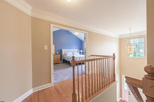 a view of a hallway to a livingroom with furniture and windows