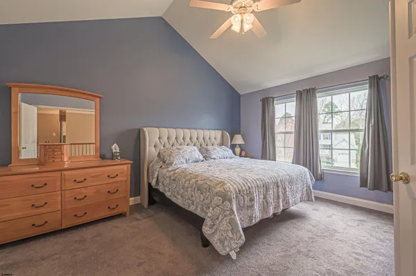 a spacious bedroom with a bed and a dresser