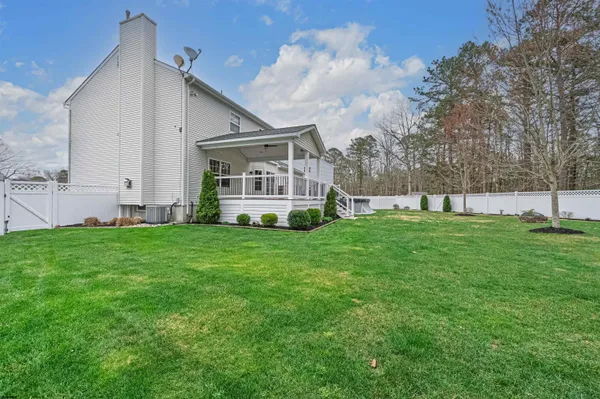 a view of a house with a big yard and large trees