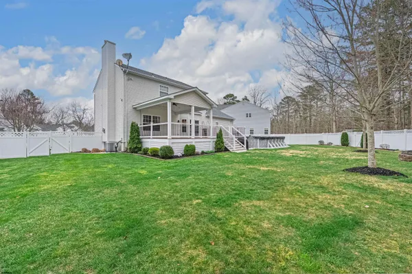a view of a house with a big yard and large trees