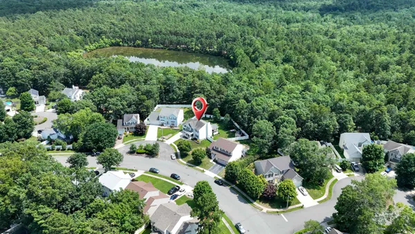 an aerial view of a house with a yard and lake view
