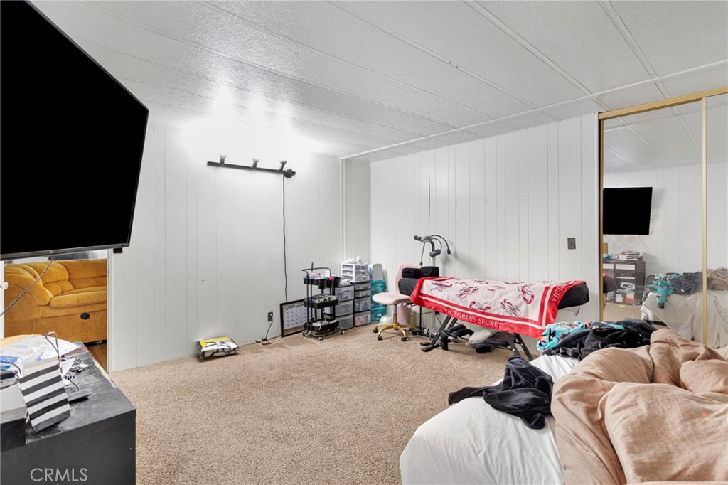 19044 Joshua Street Adelanto, CA 92301 - Photo 14 of 34 a bedroom with furniture and a flat screen tv