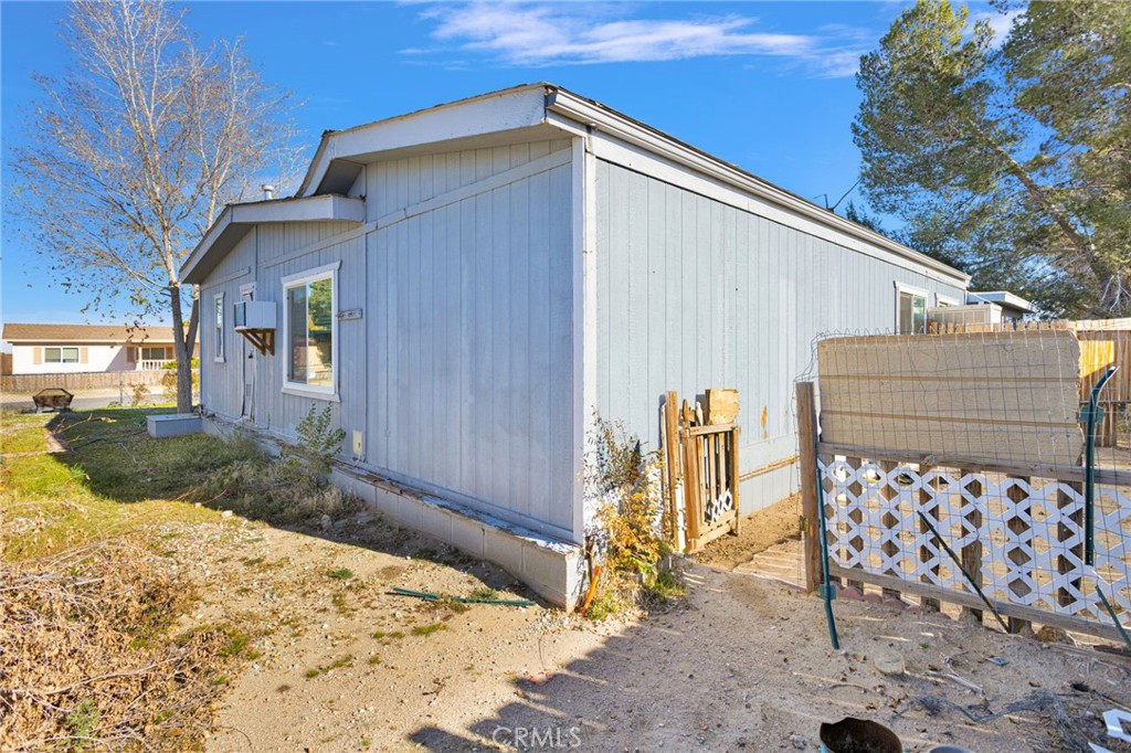 19044 Joshua Street Adelanto, CA 92301 - Photo 21 of 34 a backyard of a house with wooden fence and large trees