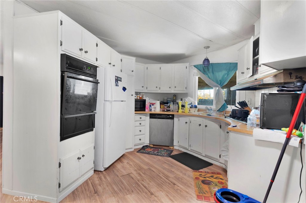 19044 Joshua Street Adelanto, CA 92301 - Photo 10 of 34 a kitchen with stainless steel appliances a refrigerator sink and cabinets