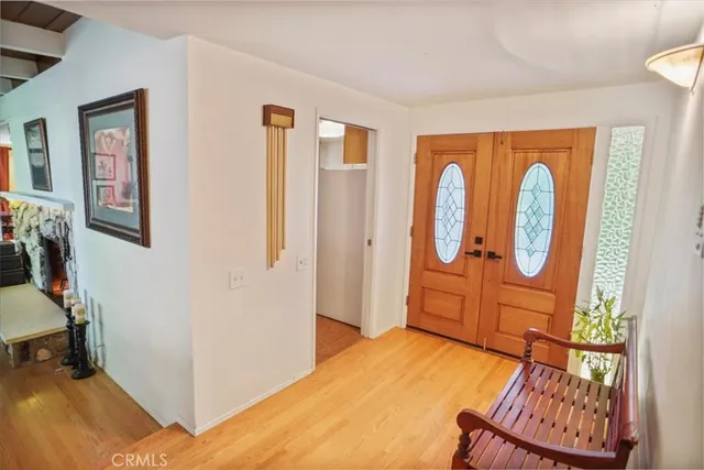 a bedroom with a bed a mirror and next to a window