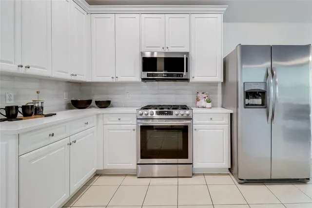 a kitchen with cabinets stainless steel appliances and a counter space