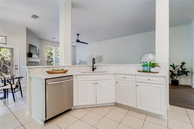 a kitchen with white cabinets and sink