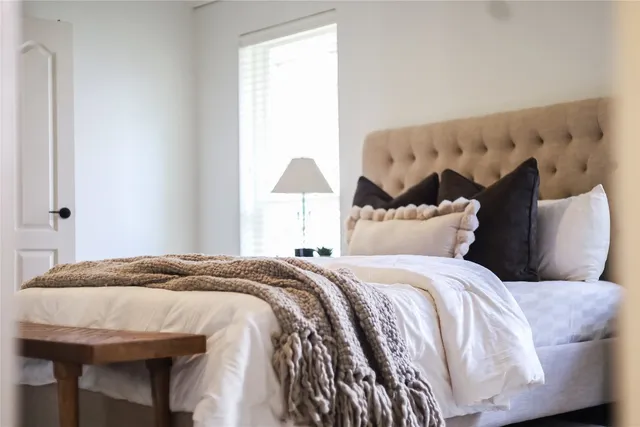 a bedroom with a bed and a lamp