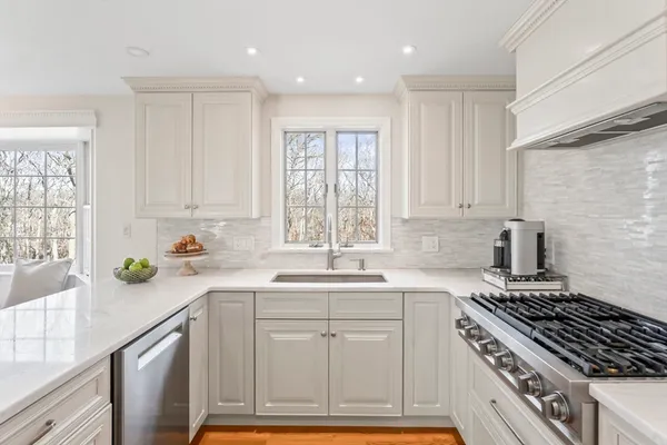 a view of a hallway to a livingroom with wooden floor and furniture