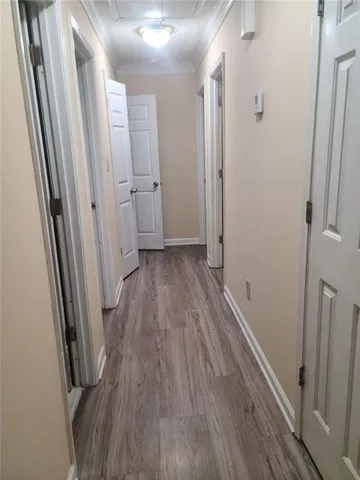a view of a hallway with wooden floor and a glass door