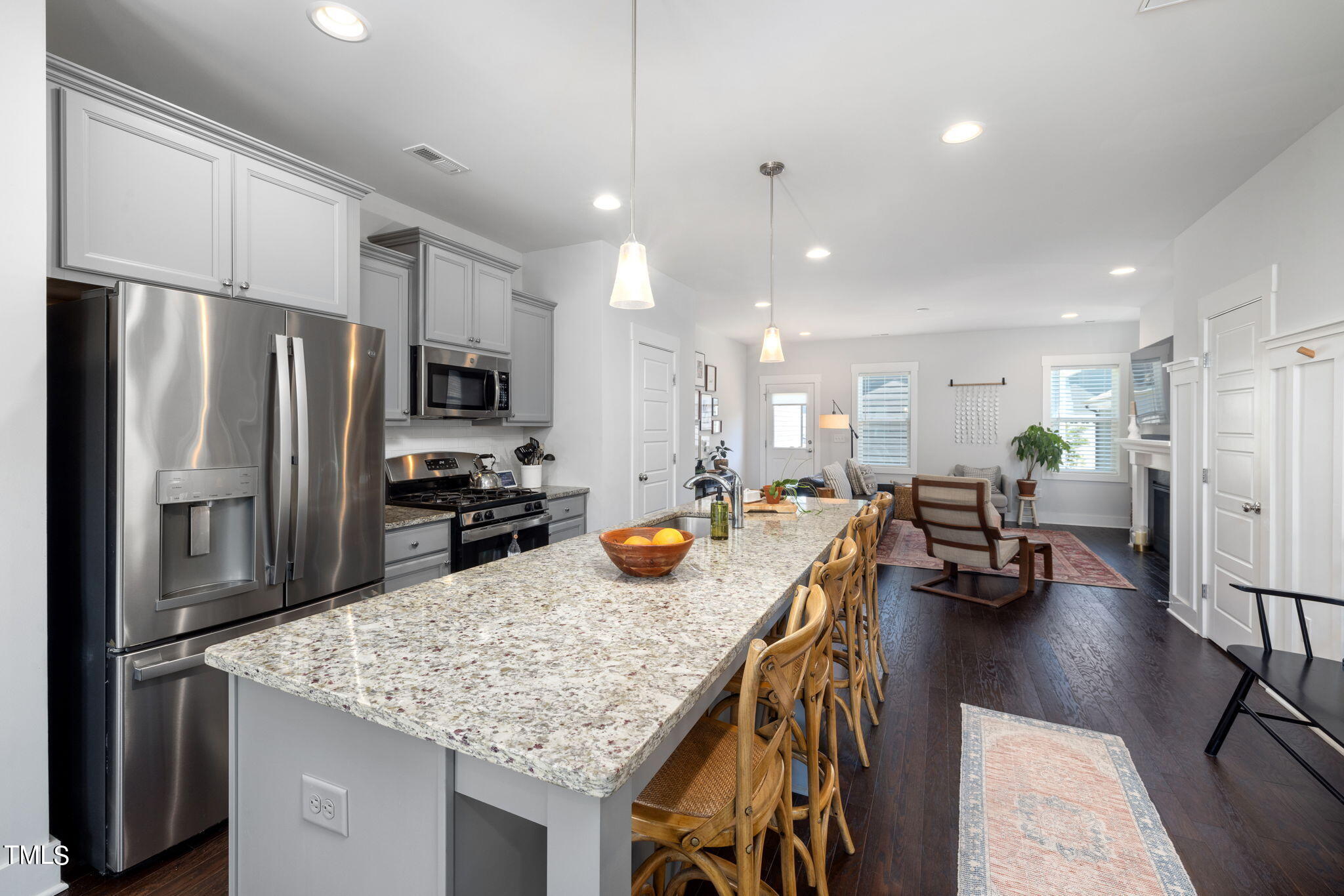 269 Douglas Falls Drive Wendell, NC 27591 - Photo 11 of 51 a kitchen with stainless steel appliances granite countertop a refrigerator a sink a stove and chairs with wooden floor