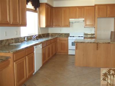 37243 Haweswater Road Indio, CA 92203 - Photo 14 of 14 a kitchen with stainless steel appliances granite countertop a sink stove and refrigerator