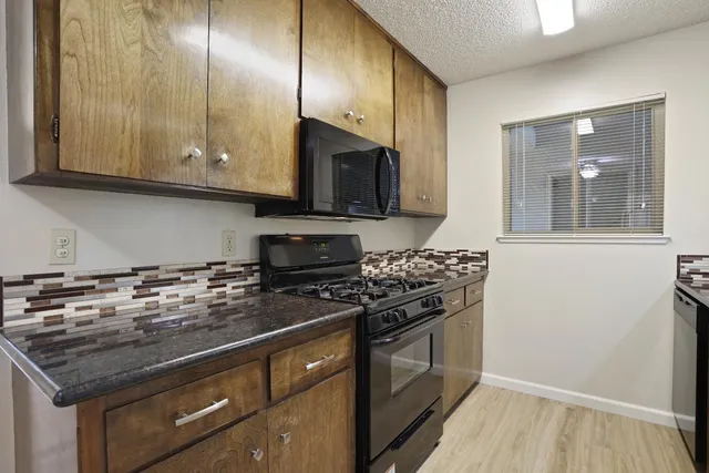 a kitchen with stainless steel appliances granite countertop a stove and a microwave