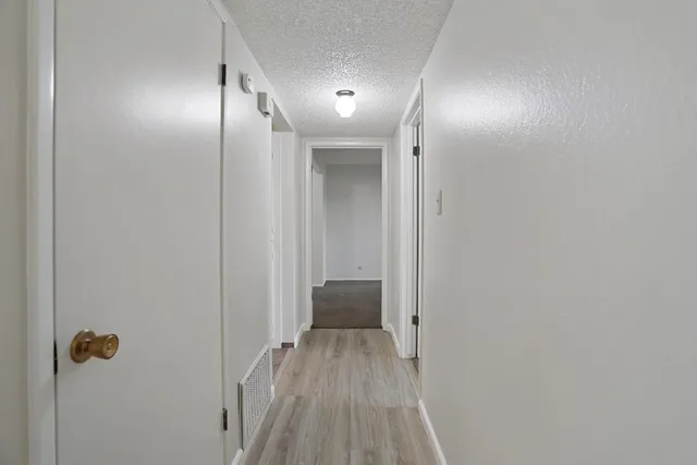 a view of a hallway with wooden floor