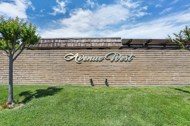 a view of a street sign with potted plants in front of it