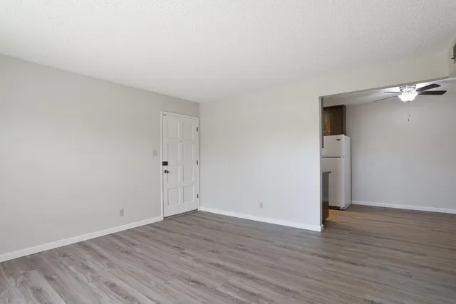 a view of an empty room with wooden floor