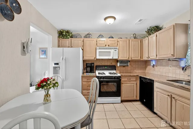 a kitchen with stainless steel appliances granite countertop a refrigerator sink and stove