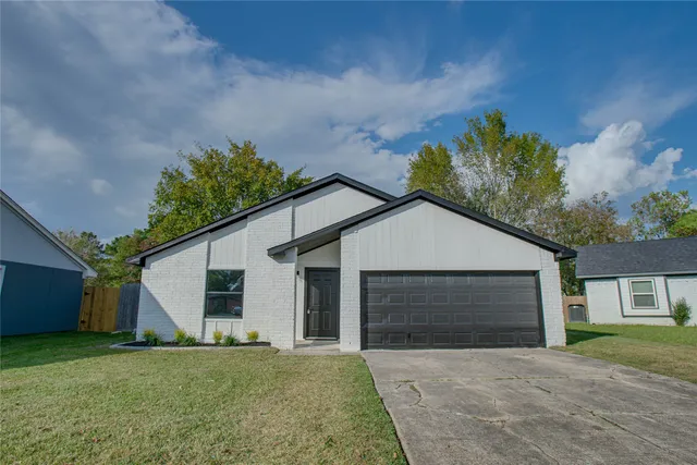 a front view of a house with a garden and yard
