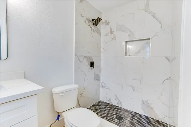 a white toilet sitting next to a bathroom sink