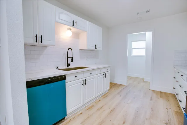 a kitchen with a sink cabinets and wooden floor
