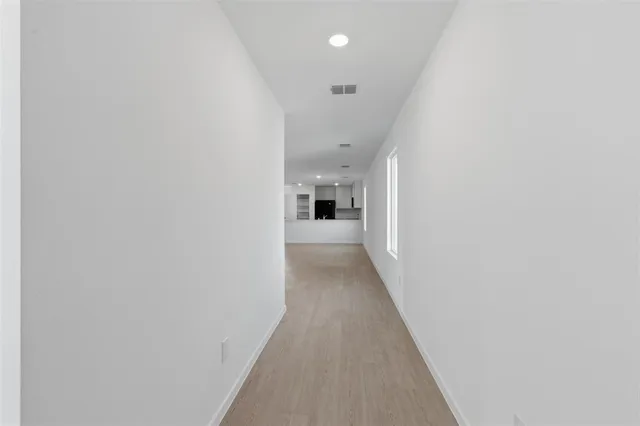 a view of a hallway with wooden floor