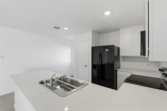 a kitchen with a refrigerator and cabinets