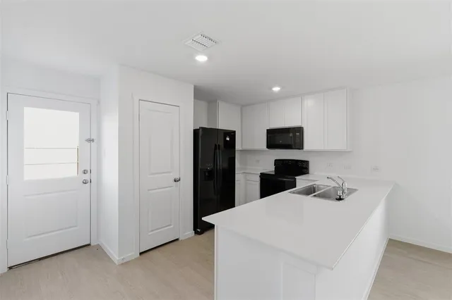 a kitchen with refrigerator cabinets and a refrigerator