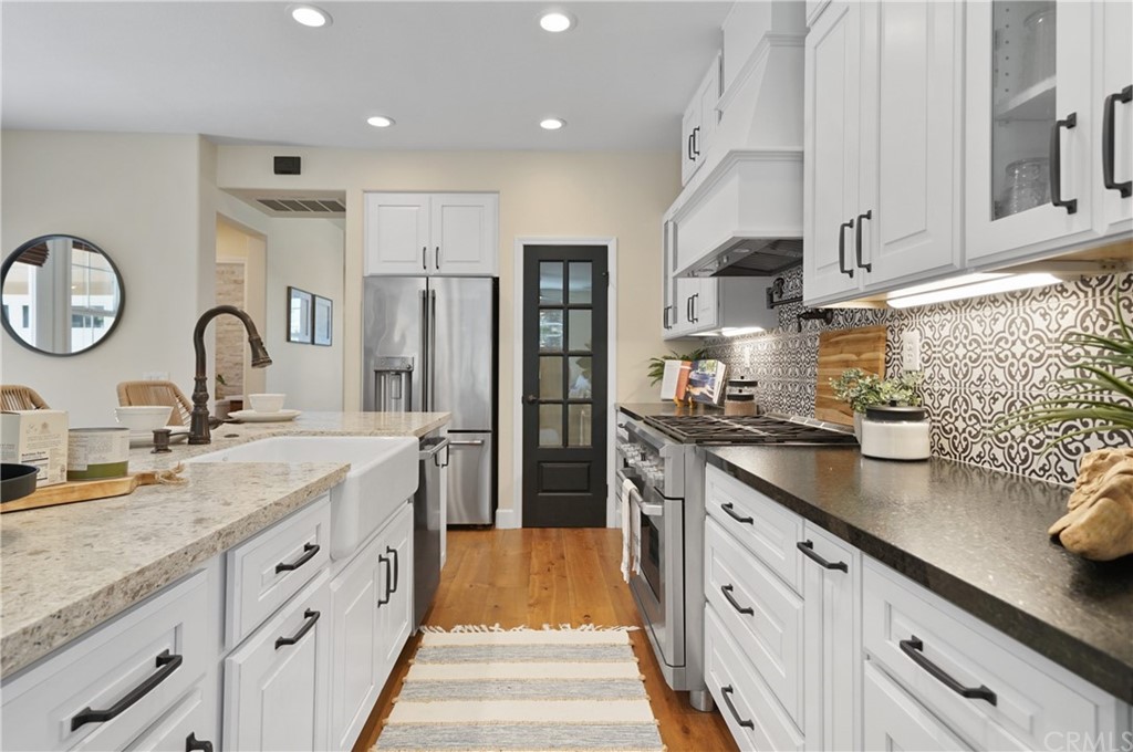 56 Tuberose Street Ladera Ranch, CA 92694 - Photo 17 of 55 a kitchen with stainless steel appliances granite countertop a sink dishwasher a refrigerator and a stove with wooden floor