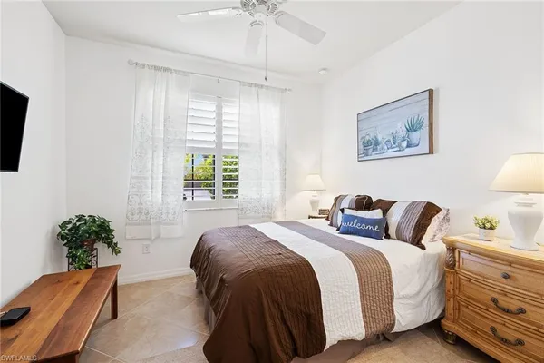 a bedroom with a bed and a potted plant