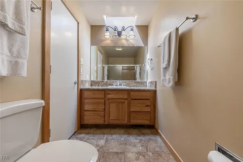 a bathroom with a granite countertop sink a mirror and shower