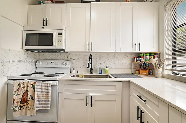 a kitchen with stainless steel appliances granite countertop a sink a stove and a microwave