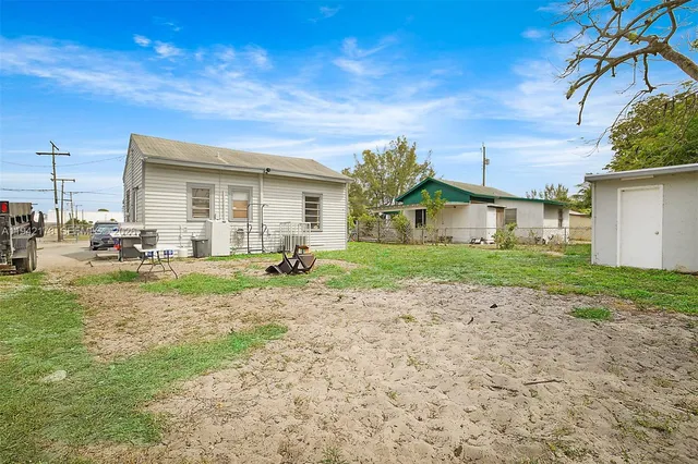 a view of a house with backyard and sitting area