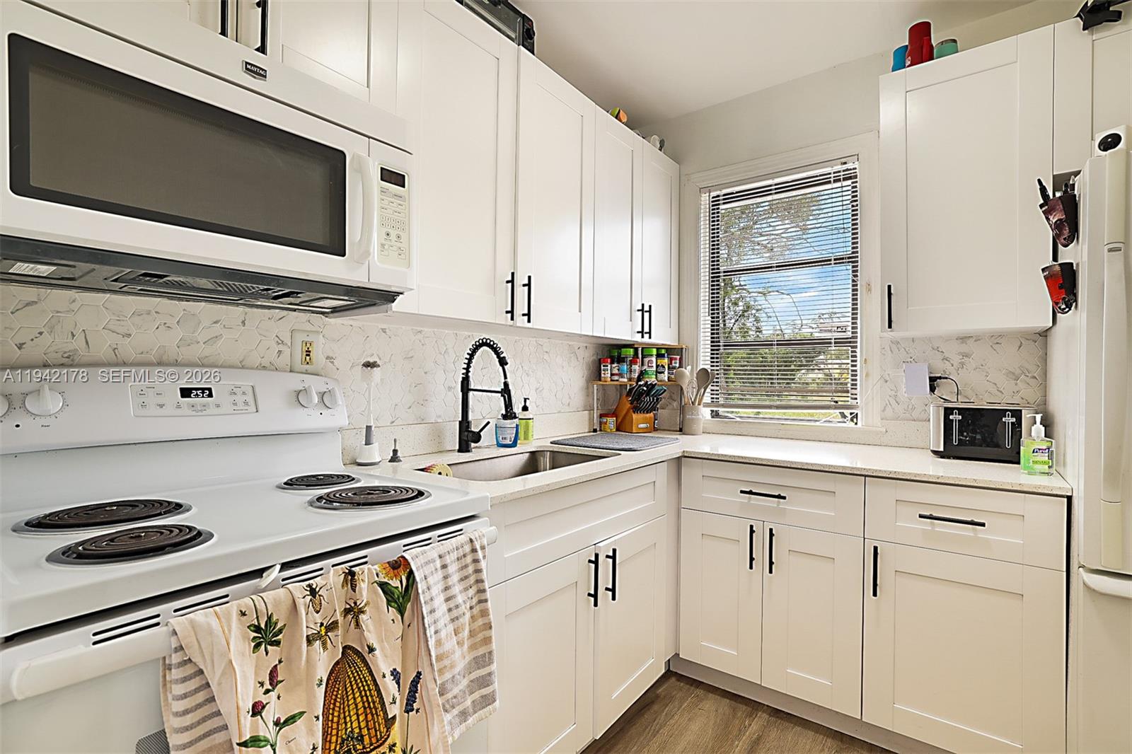 3021 Avenue J Riviera Beach, FL 33404 - Photo 10 of 17 a kitchen with stainless steel appliances granite countertop a sink a stove and microwave