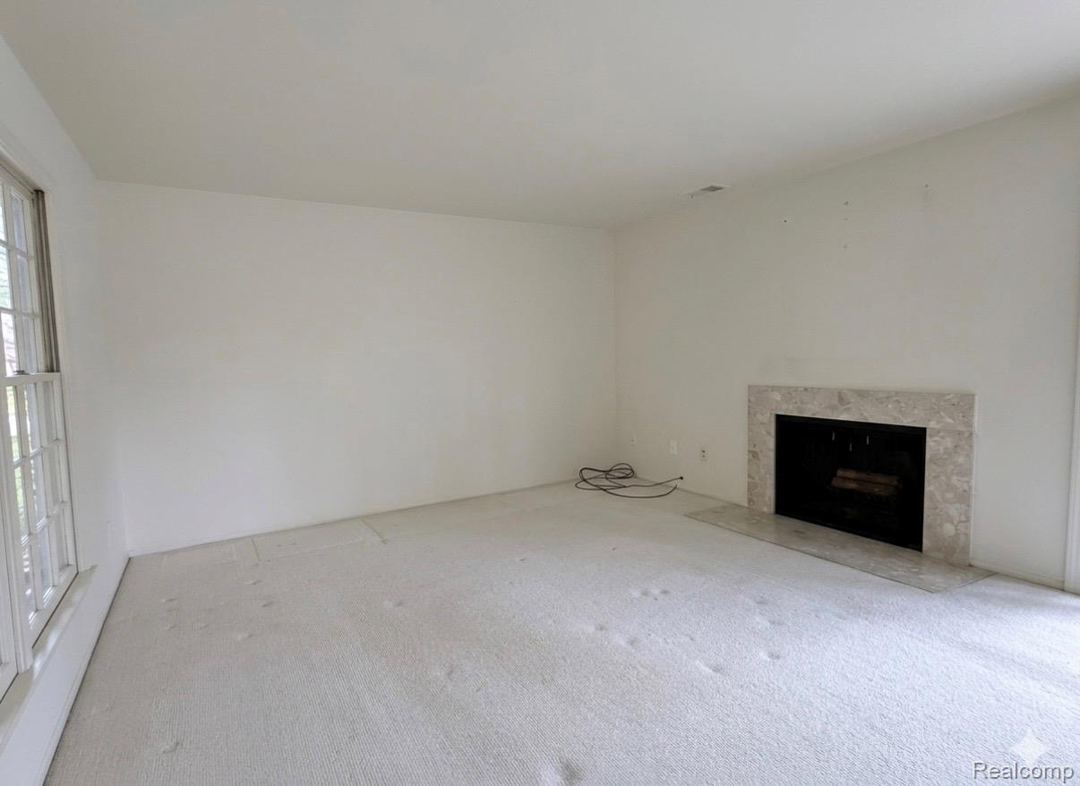 24219 Evergreen Road, Unit 39 Southfield, MI 48075 - Photo 10 of 11 Unfurnished living room featuring carpet and a fireplace